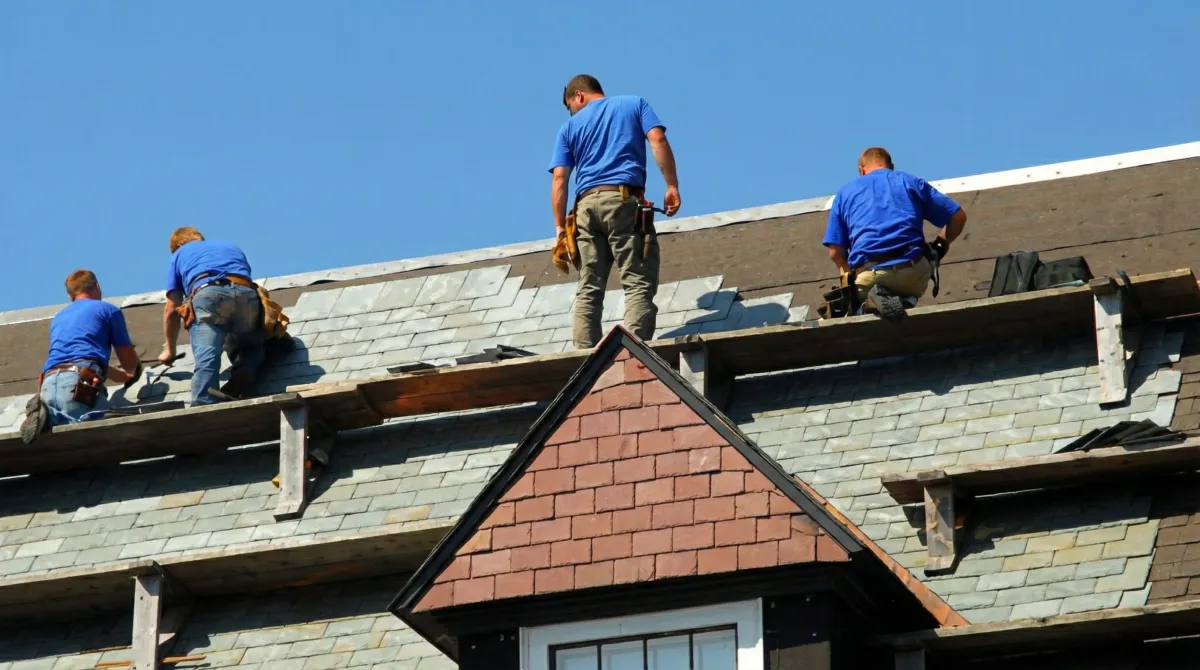 Roof replacement in progress with a team of professional contractors installing new shingles on a residential home in Tuscaloosa, AL